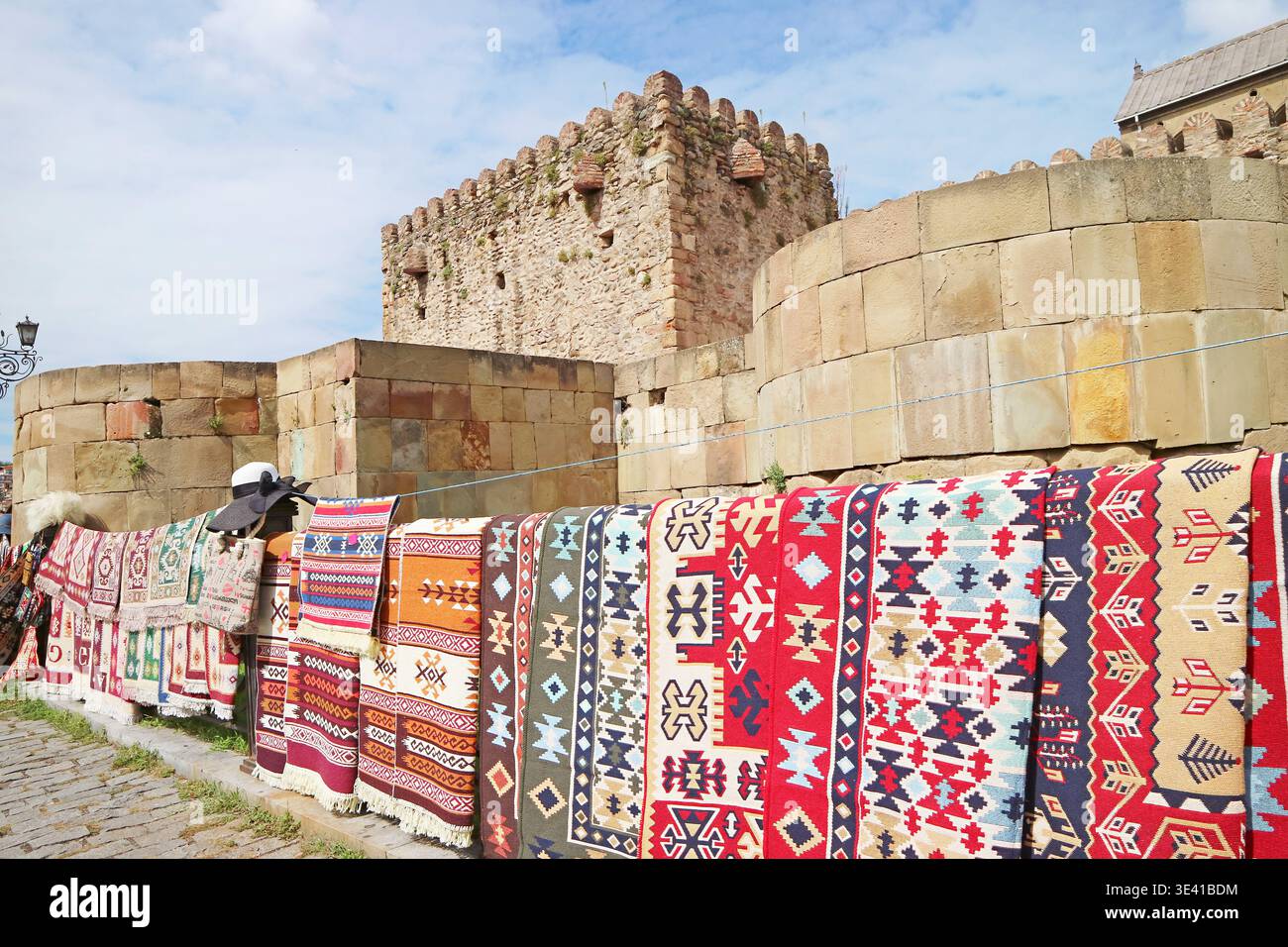 Verschiedene Muster von Teppichen zum Verkauf an der Außenmauer der Svetitskhoveli Kathedrale in Mzcheta, der ehemaligen Hauptstadt von Georgien Stockfoto