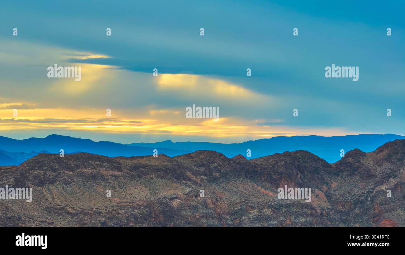 Golden Hour Mountains und dramatischer Himmel über Wüstenlandschaft Stockfoto