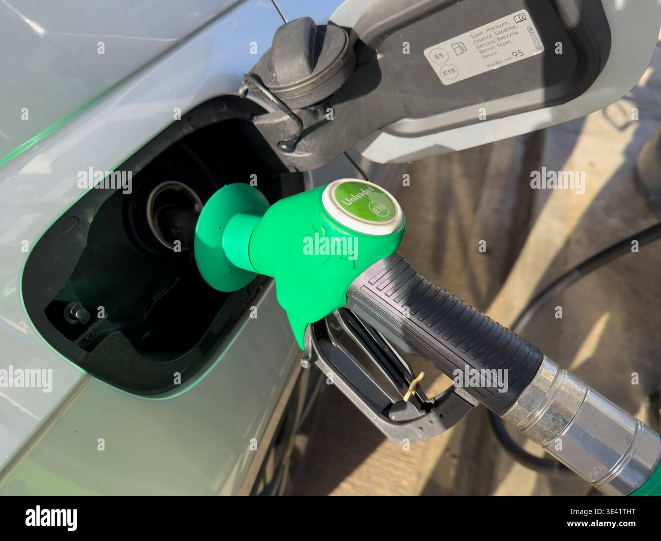 Nahaufnahme der Kraftstoffdüse der Kraftstoffpumpe, die den Tank eines Fahrzeugs füllt. - Smartphone-aufgenommenes Stockfoto