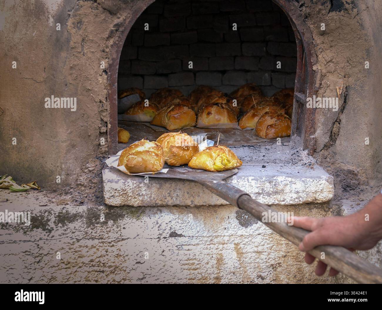 Traditionelles zypriotisches ostergebäck mit einer Mischung aus verschiedenen Käsesorten und halloumi, gebacken im Tonofen mit einer Holzschalen Flaouna Stockfoto