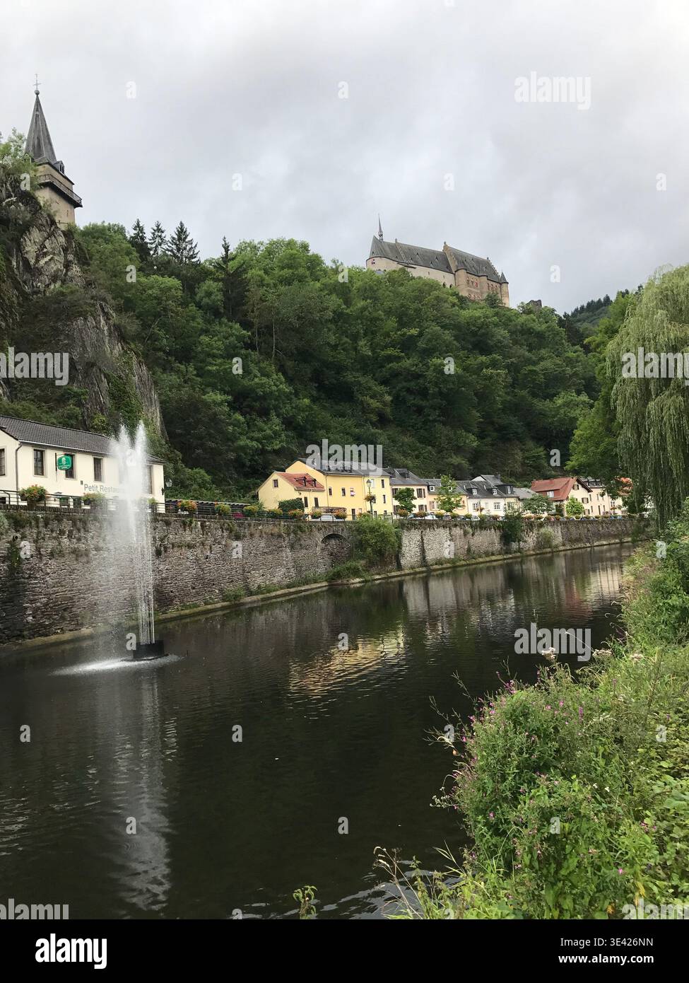 Idyllischer Blick auf die bezaubernde Stadt Vianden am Fluss Our mit kleinen historischen Häusern am Ufer. Die farbenfrohen Gebäude. Stockfoto