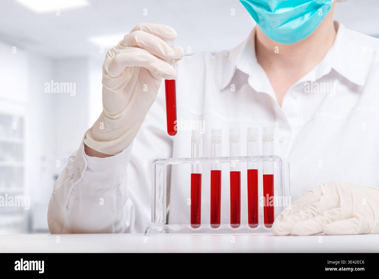 Nahaufnahme von medizinischem Fachpersonal, das Blutproben über dem Reagenzglasgestell hält, Labordiagnostik und wissenschaftliche Testumgebung Stockfoto