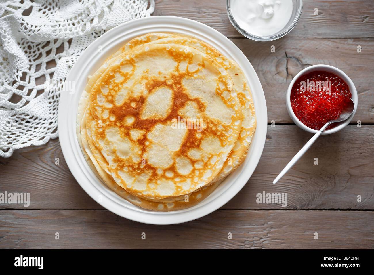 Hausgemachte, dünne Crepes mit rotem Kaviar und Creme. Herzhafte Pfannkuchen mit Lachsfischkaviar. Maslenitsa Karneval. Stockfoto