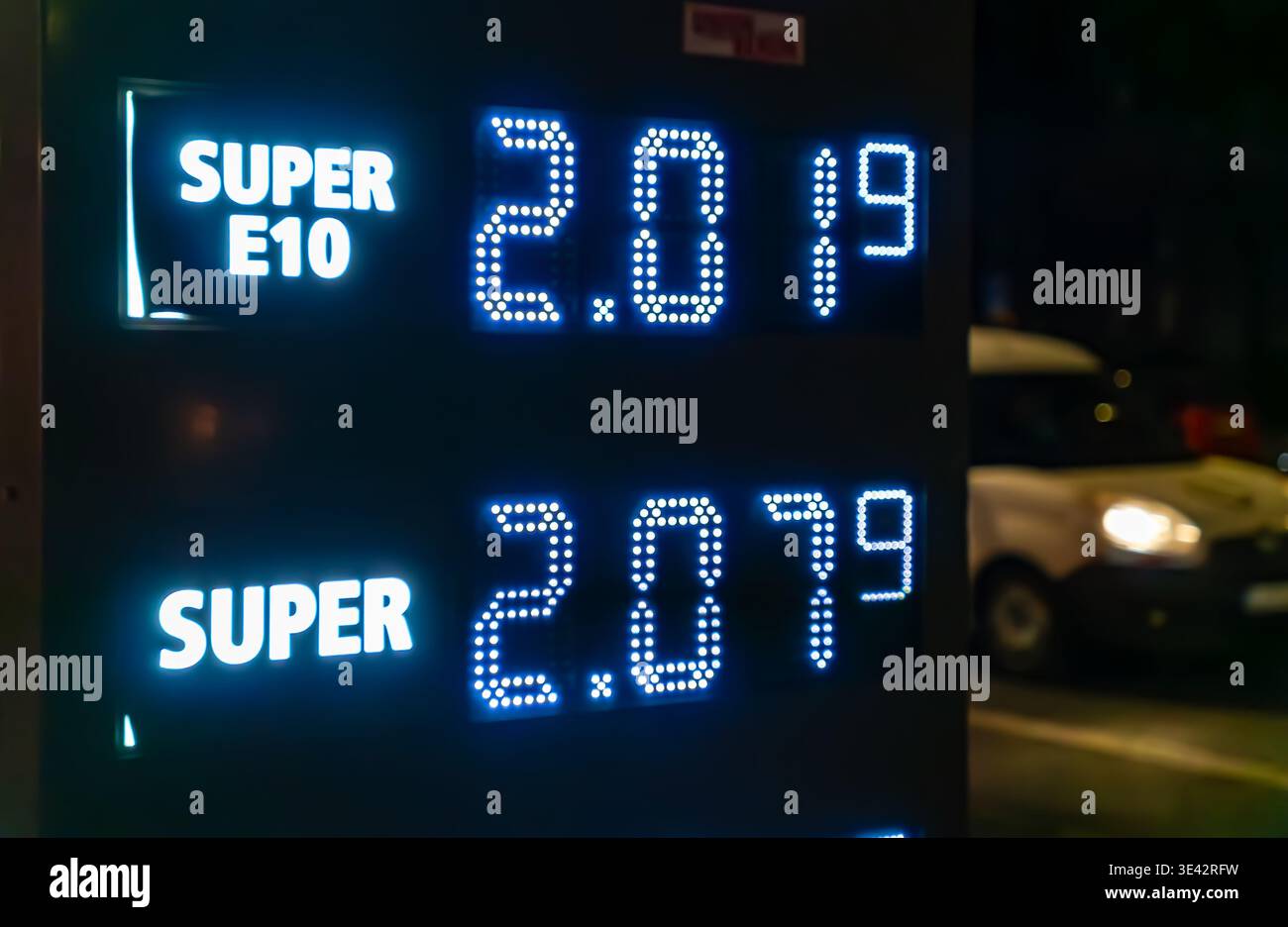 Nahaufnahme der beleuchteten Kraftstoffpreise auf der Preistafel einer Tankstelle bei Nacht, Editorial. Stockfoto