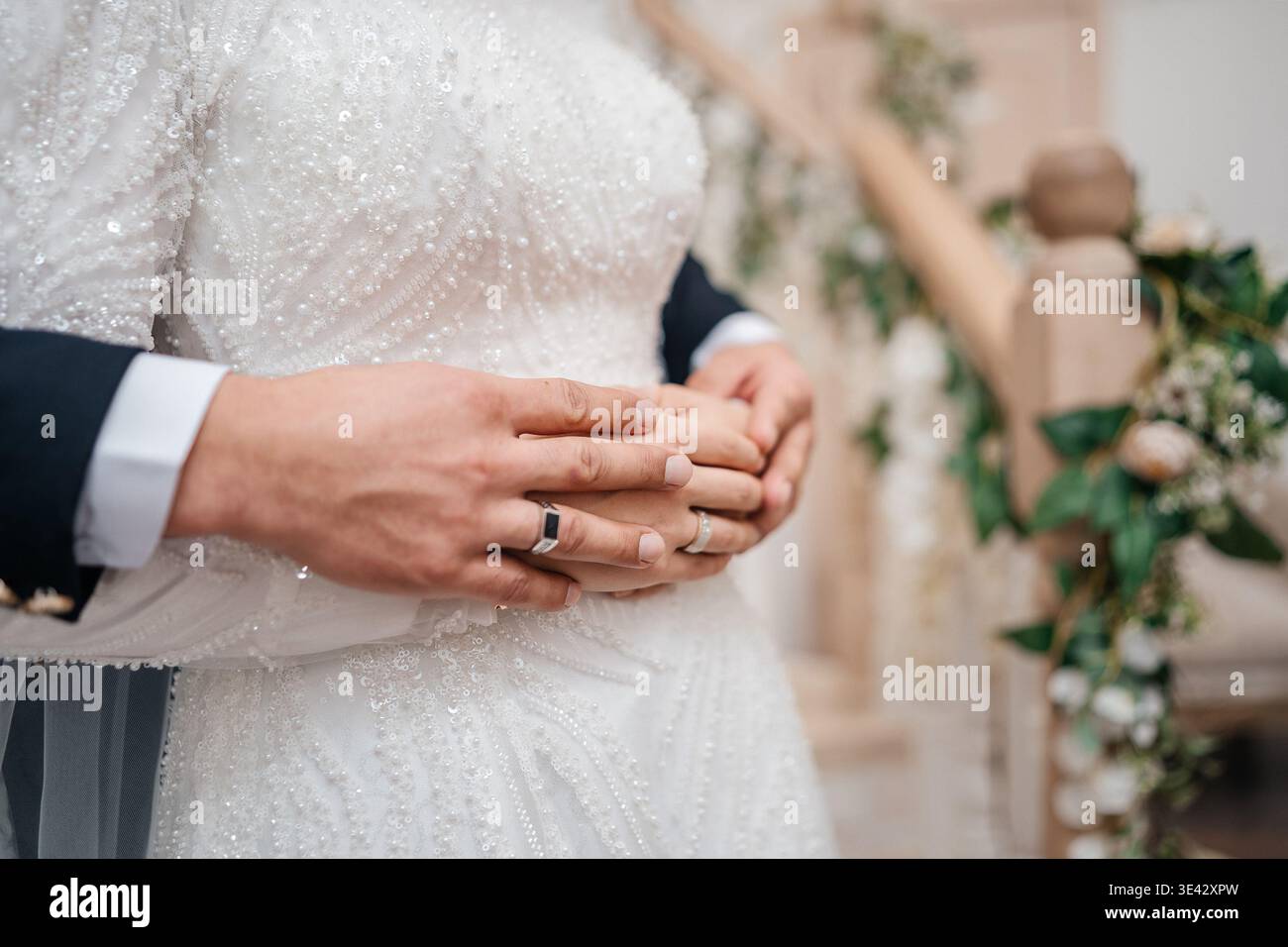 Schließen Sie Die Hände Über Die Taille Der Bräute, Die Hochzeitsringe Und Anzug Zeigen, Weiche Stoffstruktur. Stockfoto