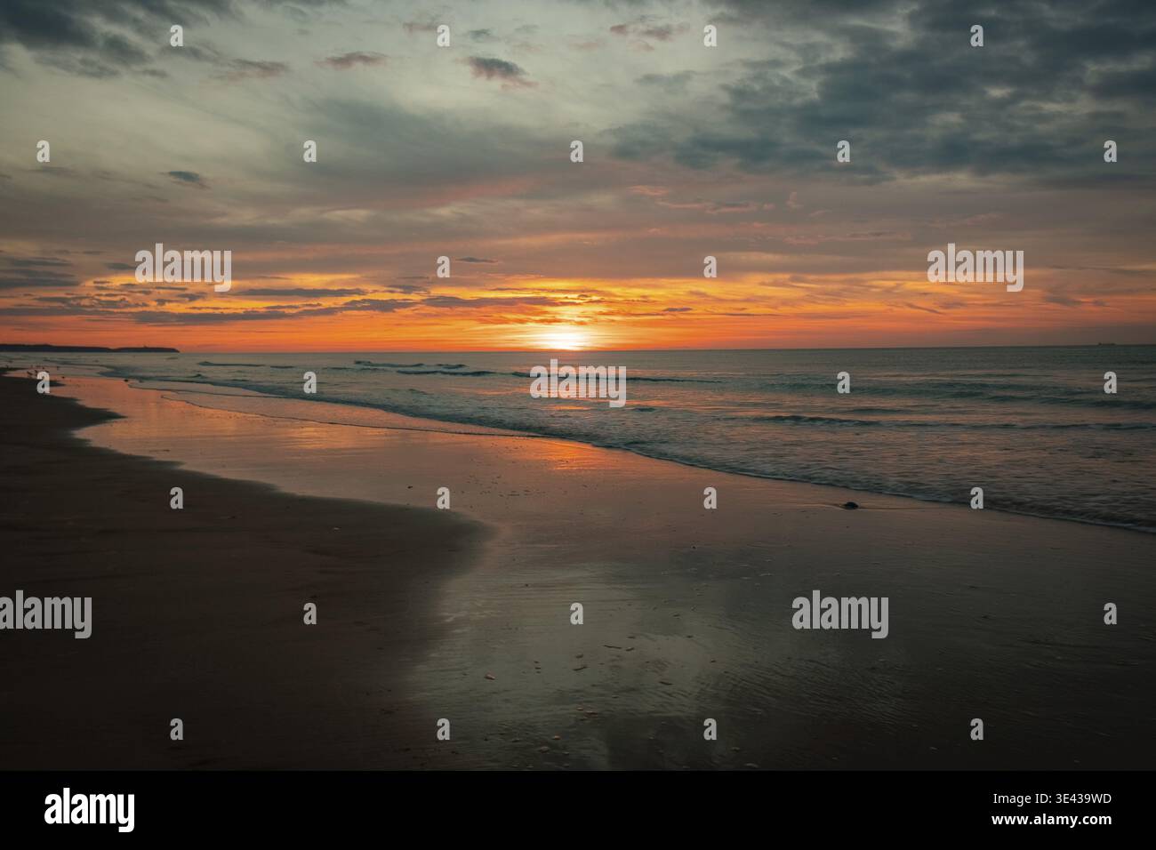 Wunderschöner Sonnenuntergang über dem Meer, mit ruhigen Wellen und lebendigen Farben des Abendhimmels an der Küste Stockfoto