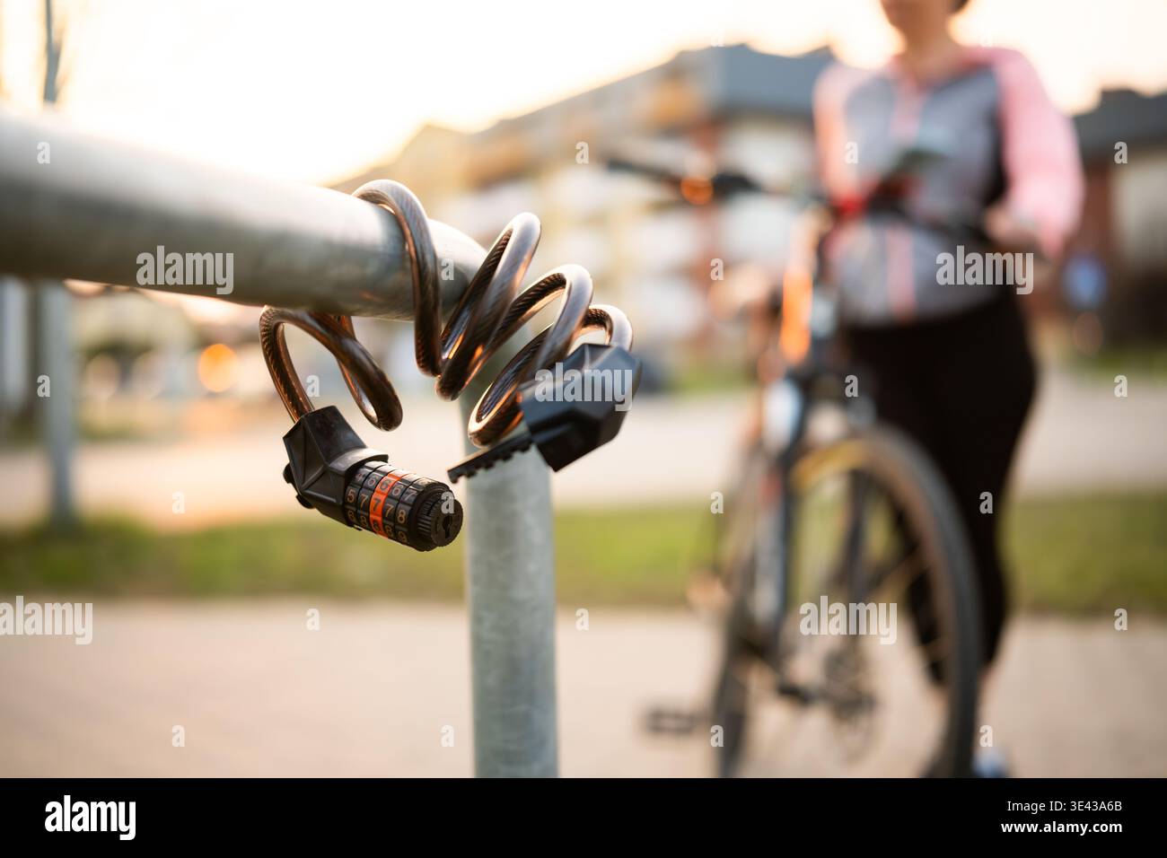 Fahrradcode-Sperre gegen weibliche Fahrradfahrer auf Einem Fahrradparkplatz Stockfoto