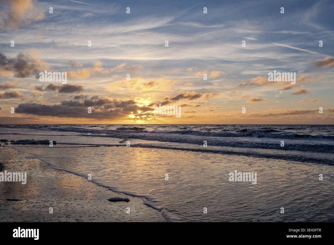Der atemberaubend schöne Sonnenuntergang über dem riesigen Ozean zeigt lebendige Farben und sanfte, rollende Wellen Stockfoto