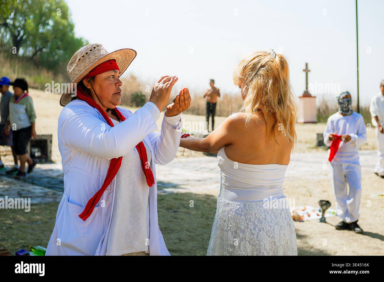 Ein traditioneller Heiler führt ein energetisches Reinigungsritual an einer jungen Frau in einer heiligen Umgebung im Freien in Mexiko durch. Stockfoto