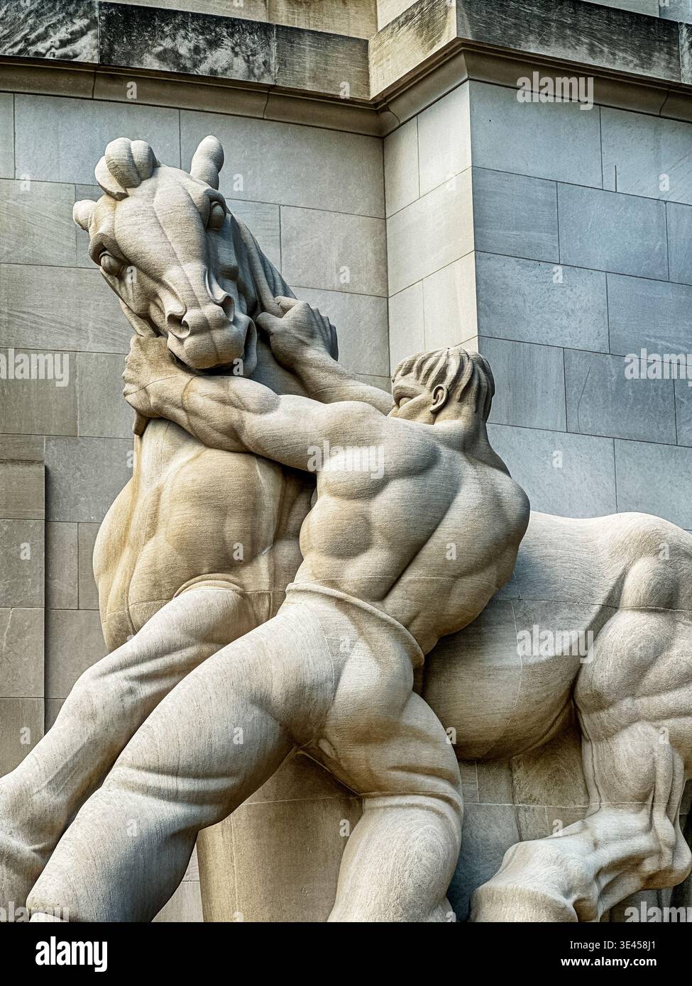 Washington, DC – 9. JUNI 2024: Die Statue eines starken Mannes, der ein Pferd hält, trägt den Titel vor dem Gebäude der Federal Trade Commission in Washington DC Stockfoto