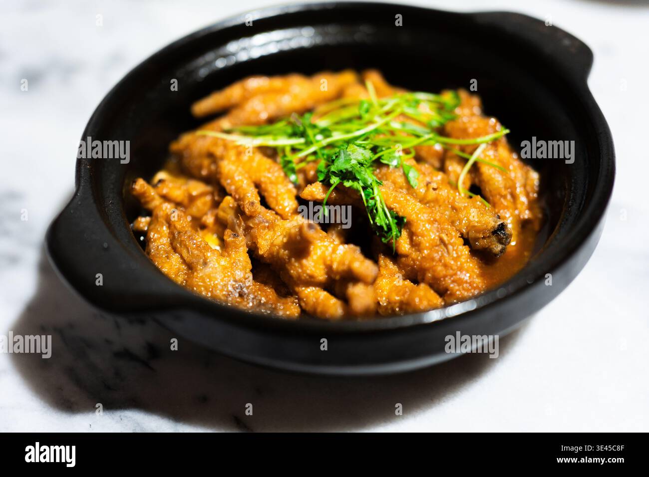 Knusprig gebratene Hähnchenfüße in Tontopf mit Koriander Garnish, kantonesische Küche, Hongkong Stockfoto