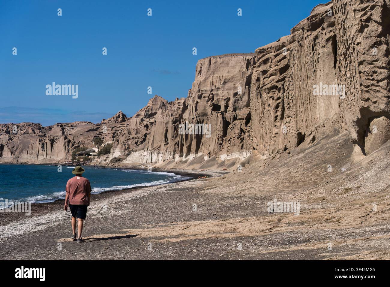 Santorin, Griechenland - 9. Oktober 2025 - Einzelgänger spazieren entlang des Vlychada-Strandes in der Nähe der hohen Klippen von Santorin Stockfoto