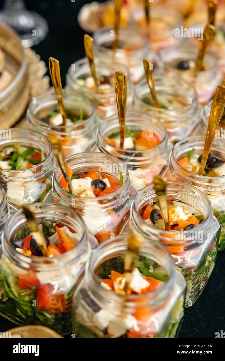 Catering-Service mit individuellen Salaten in Gläsern Stockfoto