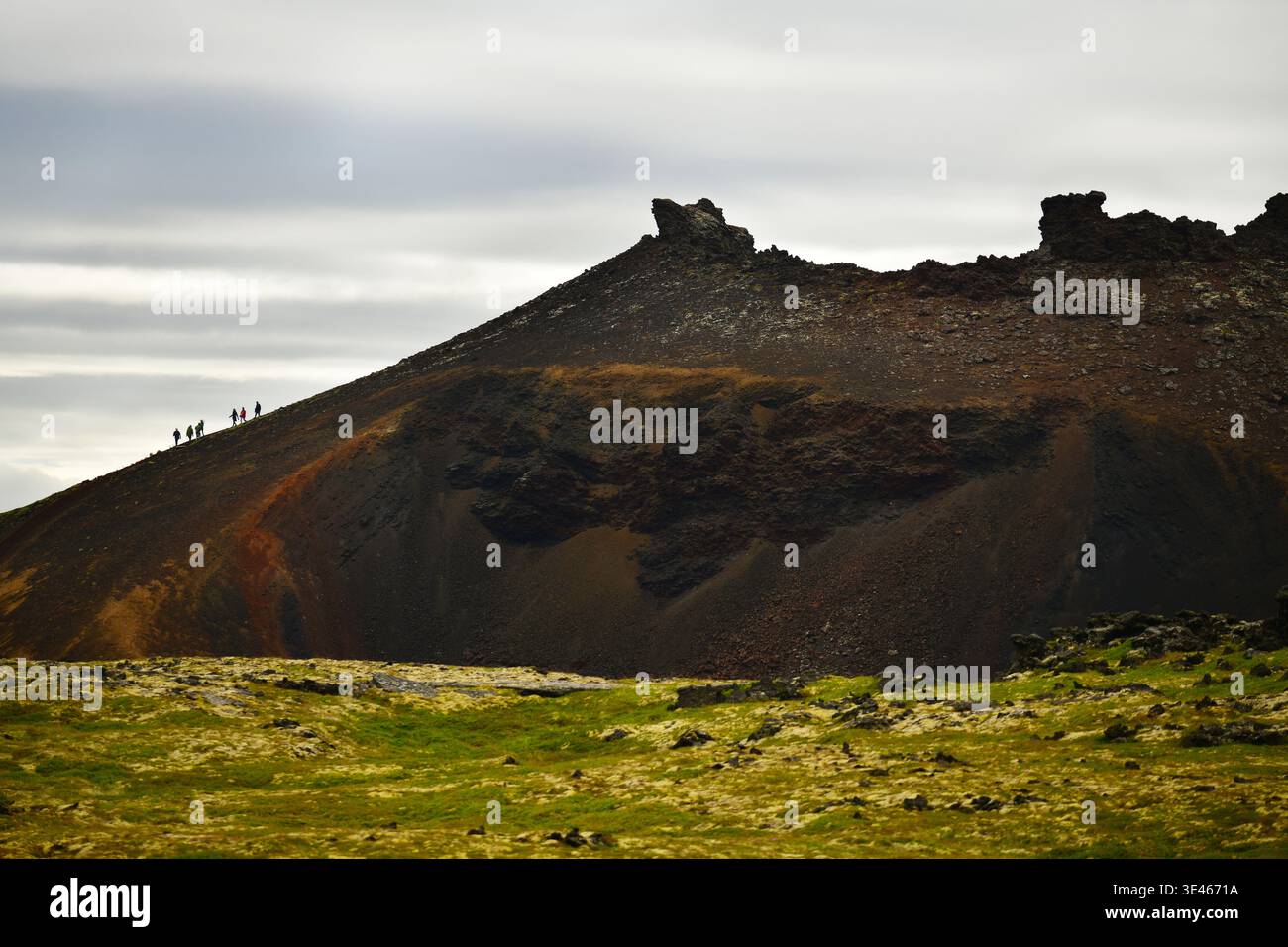 Wanderer, die den Krater eines inaktiven Vulkans in Island erklimmen Stockfoto