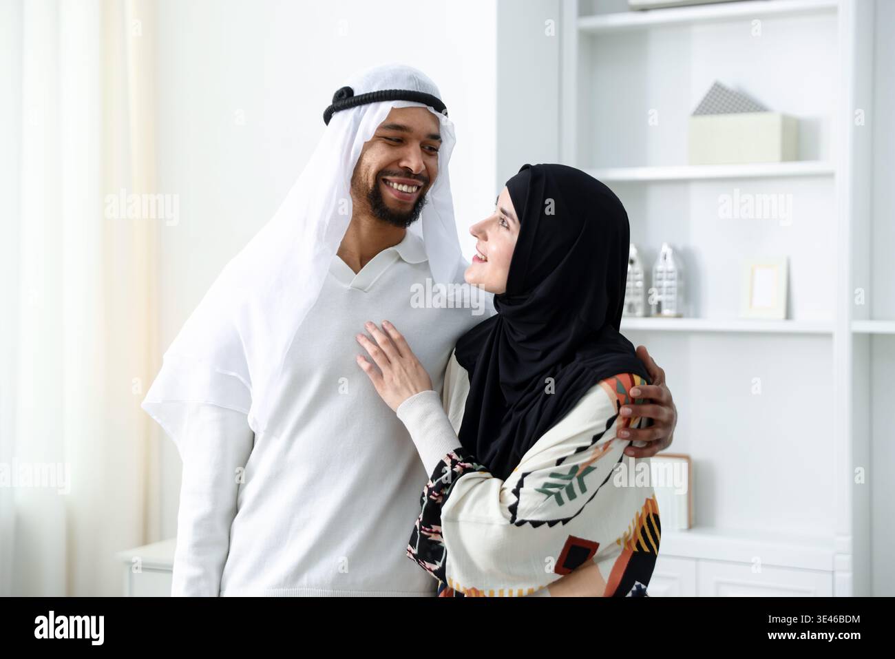 Glückliches muslimisches Paar, das sich zu Hause ansieht Stockfoto
