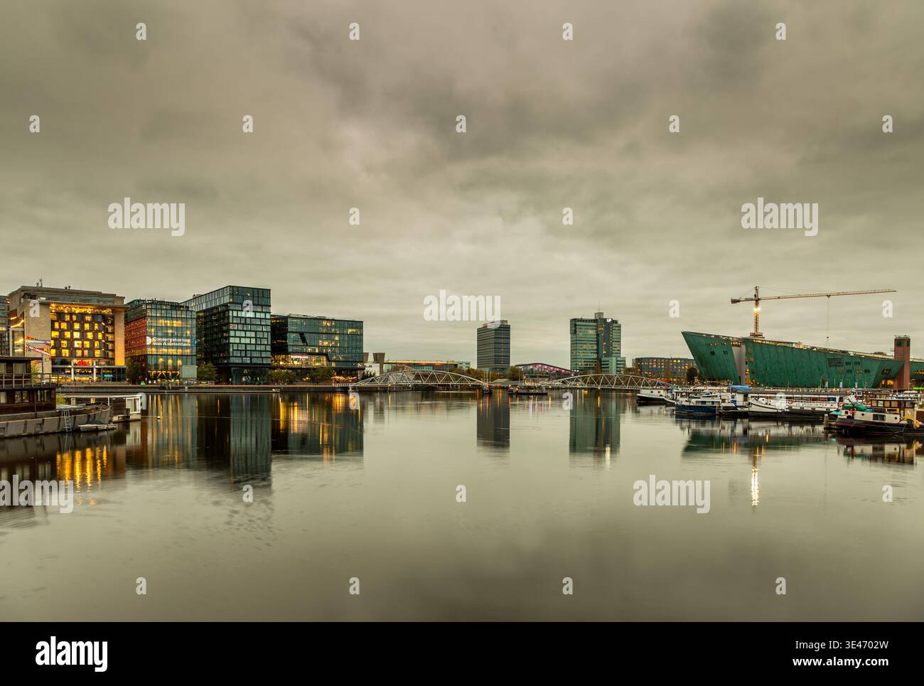 Blick auf das Oosterdok-Viertel in Amsterdam, Holland an einem bewölkten Tag, mit moderner Architektur Stockfoto