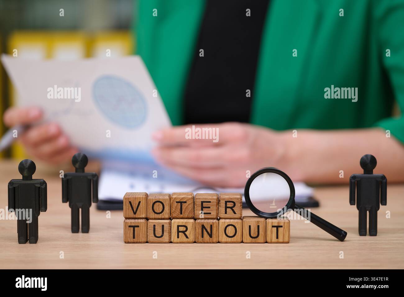 Anregende Diskussion über die Wahlbeteiligung mit Holzblöcken und Minifiguren in einem hellen Büroumfeld tagsüber Stockfoto