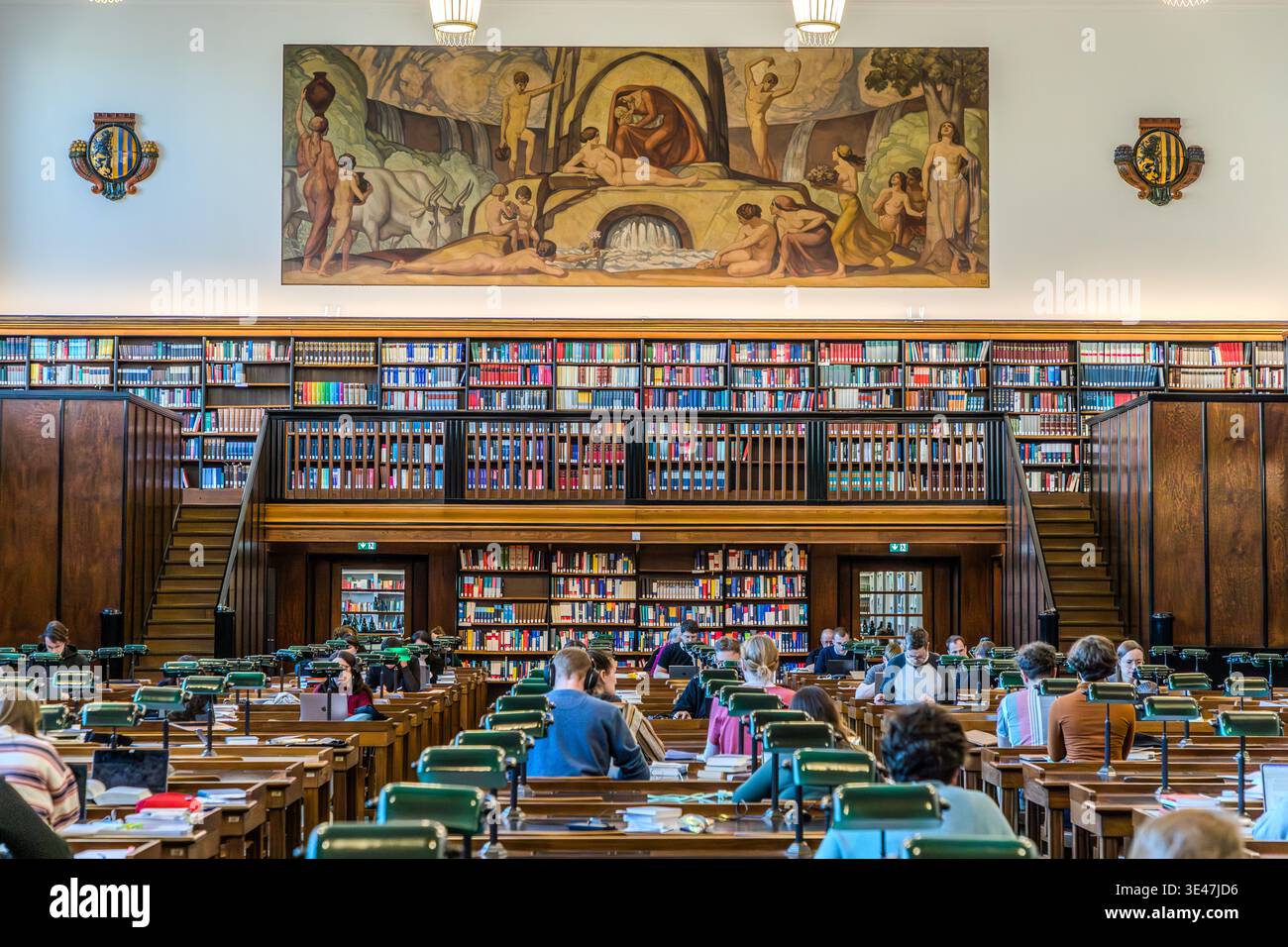 Der erste Lesesaal der Deutschen Nationalbibliothek Leipzig mit grünen Leselampen und grüner Linoleum-Arbeitsfläche. Die Wände sind mit Fresken geschmückt, die spätNazarener Motive darstellen. Leipzig, Sachsen, Deutschland Stockfoto