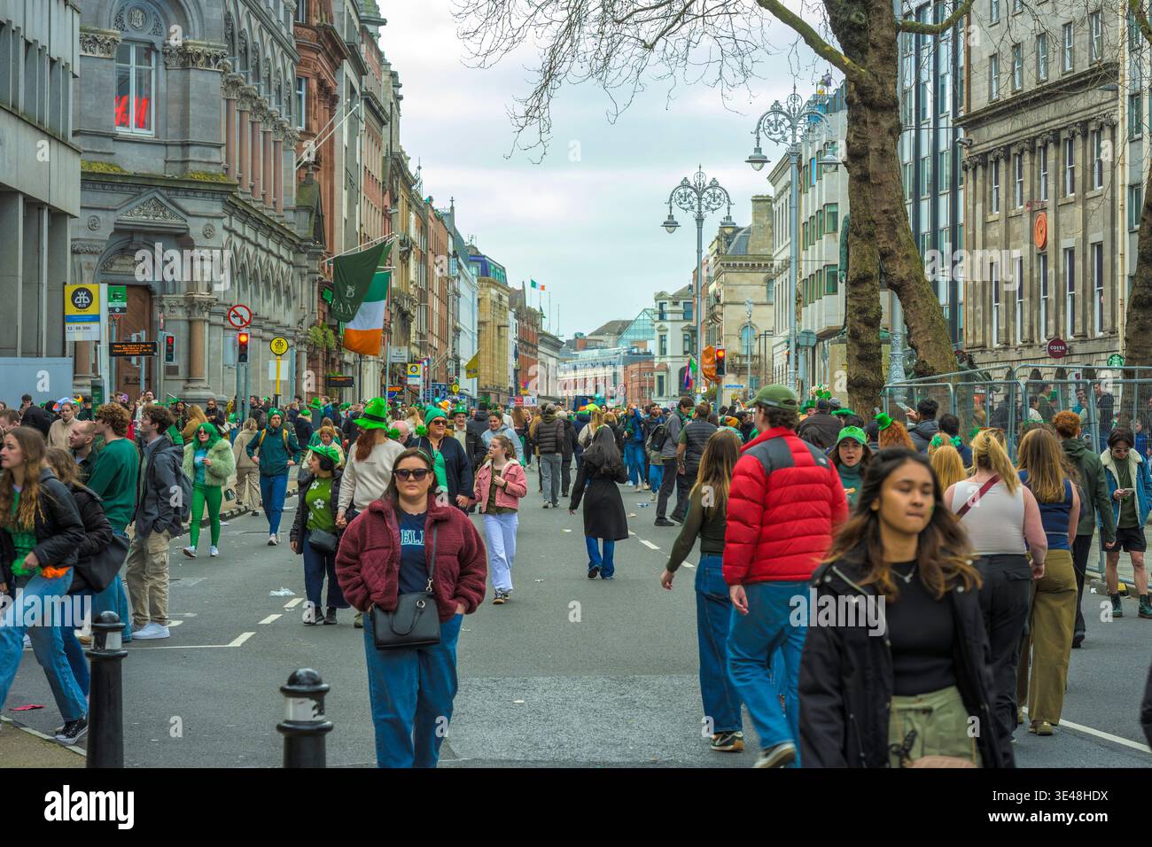 Breiter Blick auf das College Green Dublin am 17. März mit Menschenmassen und festlichen Dekorationen nach der Parade. Stockfoto