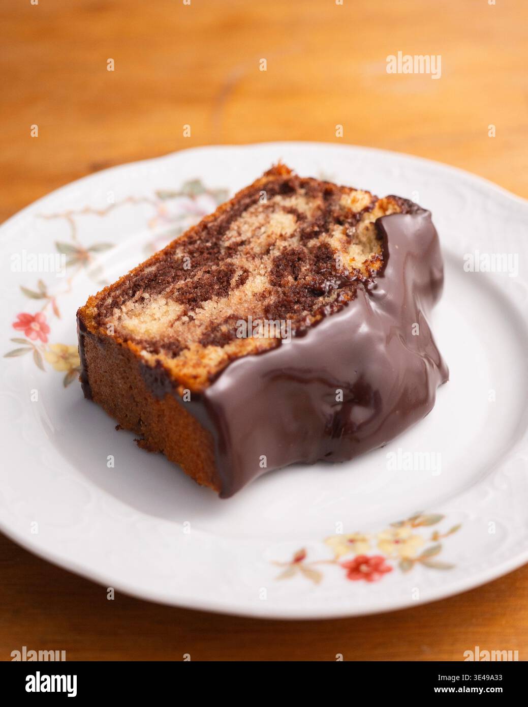 Köstlicher Marmor-Schokoladenkuchen mit glänzender Ganache und frischer Minzgarnitur Stockfoto