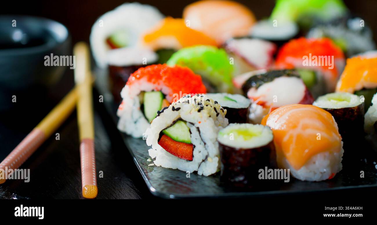 Vielfältige Auswahl an Sushi-Brötchen auf einer Platte in einem Restaurant zum Mittag- oder Abendessen in Japan Stockfoto