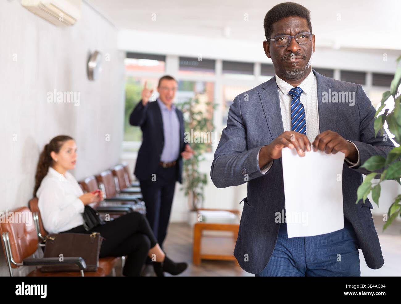 Ein erwachsener Mann wurde mit Dokumenten an der Rezeption verärgert Stockfoto