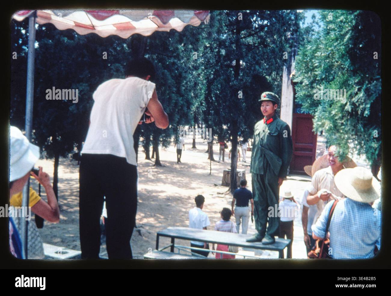 Ein junger Soldat in seiner grünen Armeeuniform, der sich draußen in einem Park fotografieren lässt. In China, 1978. Dieses Diabild wurde 1978 während einer amerikanischen Gruppenreise nach China aufgenommen, einer kulturellen Austauschtour der US-China Peoples Friendship Association. Stockfoto
