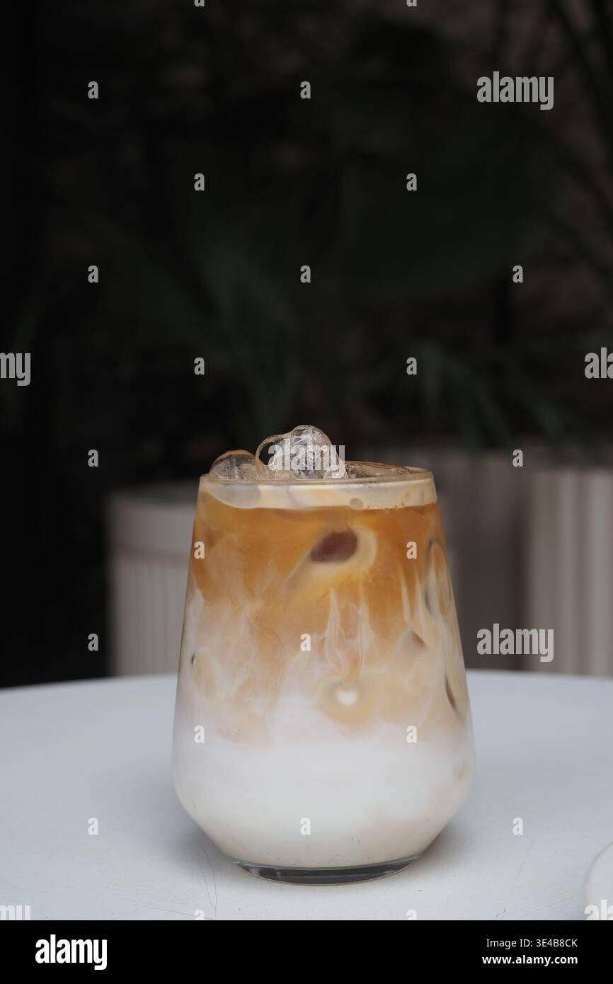 Eiskaffee mit Milch serviert in einem Glas auf einem Tisch Stockfoto
