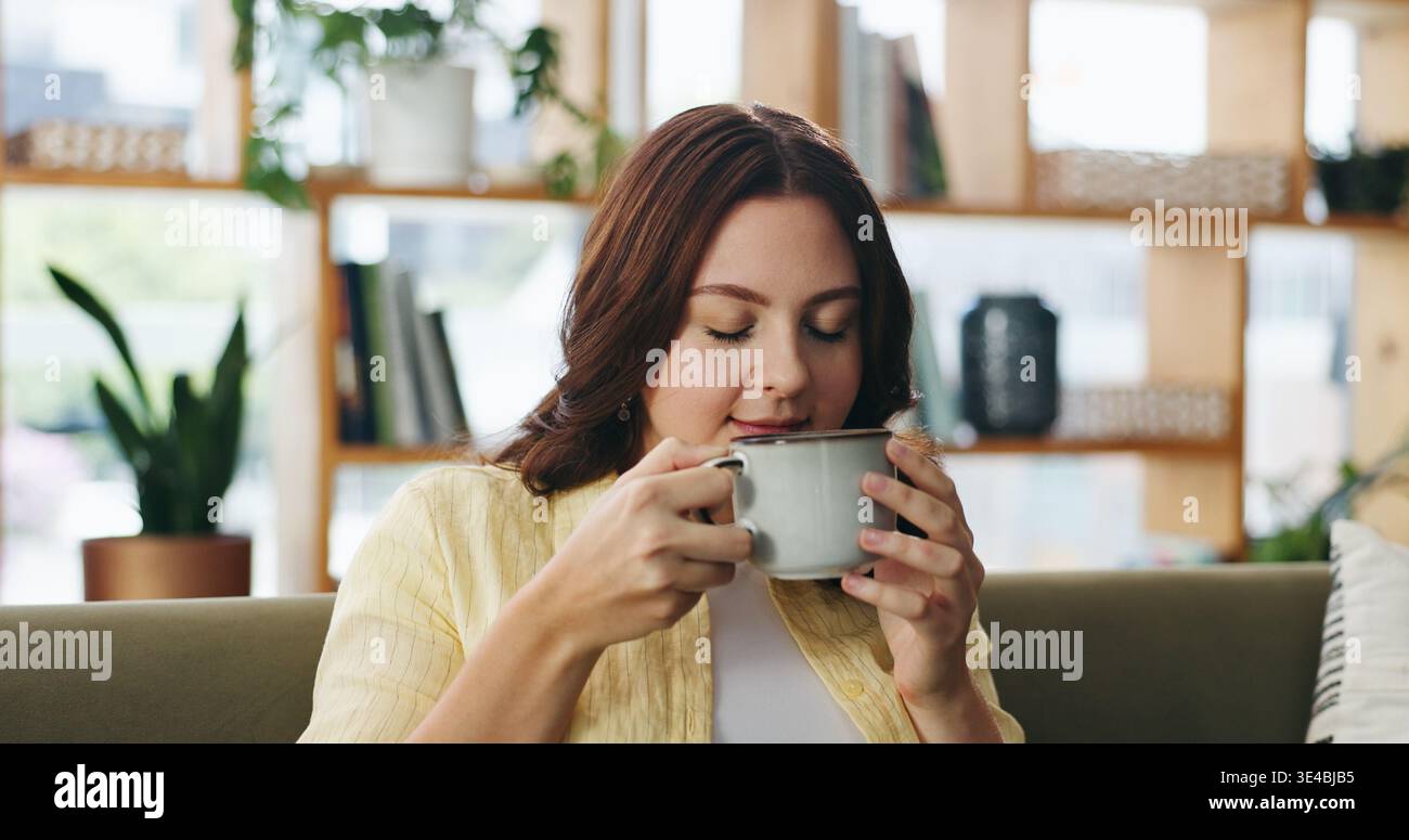 Frau, entspannen Sie sich und riechen Sie Kaffee im Haus mit Duft, ruhiger Morgenroutine und Ruhe für ein Wochenende. Person, kühlen und trinken Aroma im Wohnzimmer Stockfoto