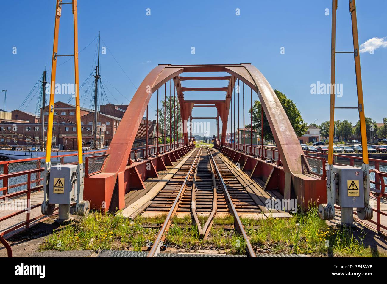 Alte Eisenbahnbrücke über einen Kanal mit Bartoren in einem Industriegebiet Stockfoto