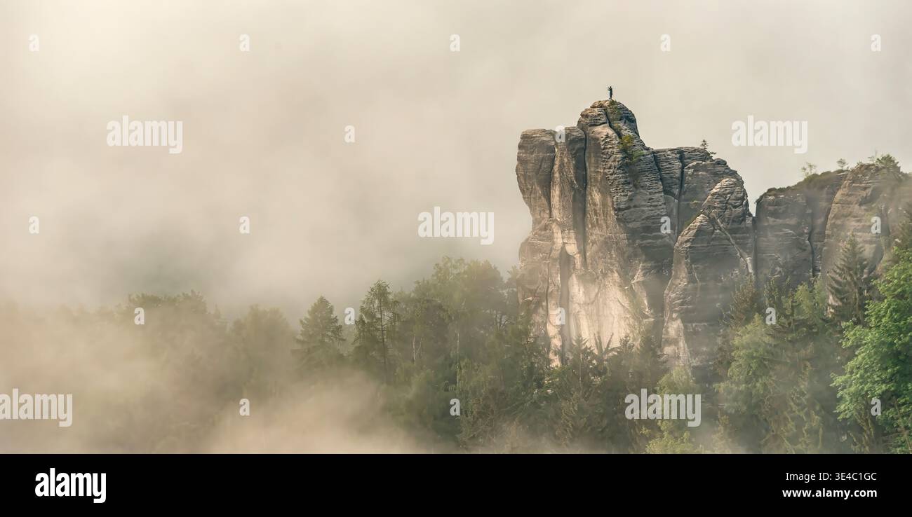 Einsamer Mönchsfelsen im Nationalpark Sächsische Schweiz, Deutschland, dramatische Sandsteinklippen, die sich durch Morgennebel erheben. Stockfoto