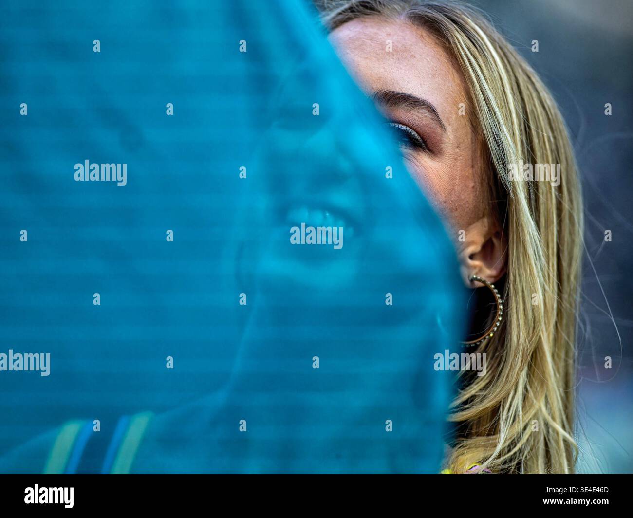 Eine Frau auf einem Fußballfeld mit einem netten Lächeln, versteckt hinter einem vail Stockfoto