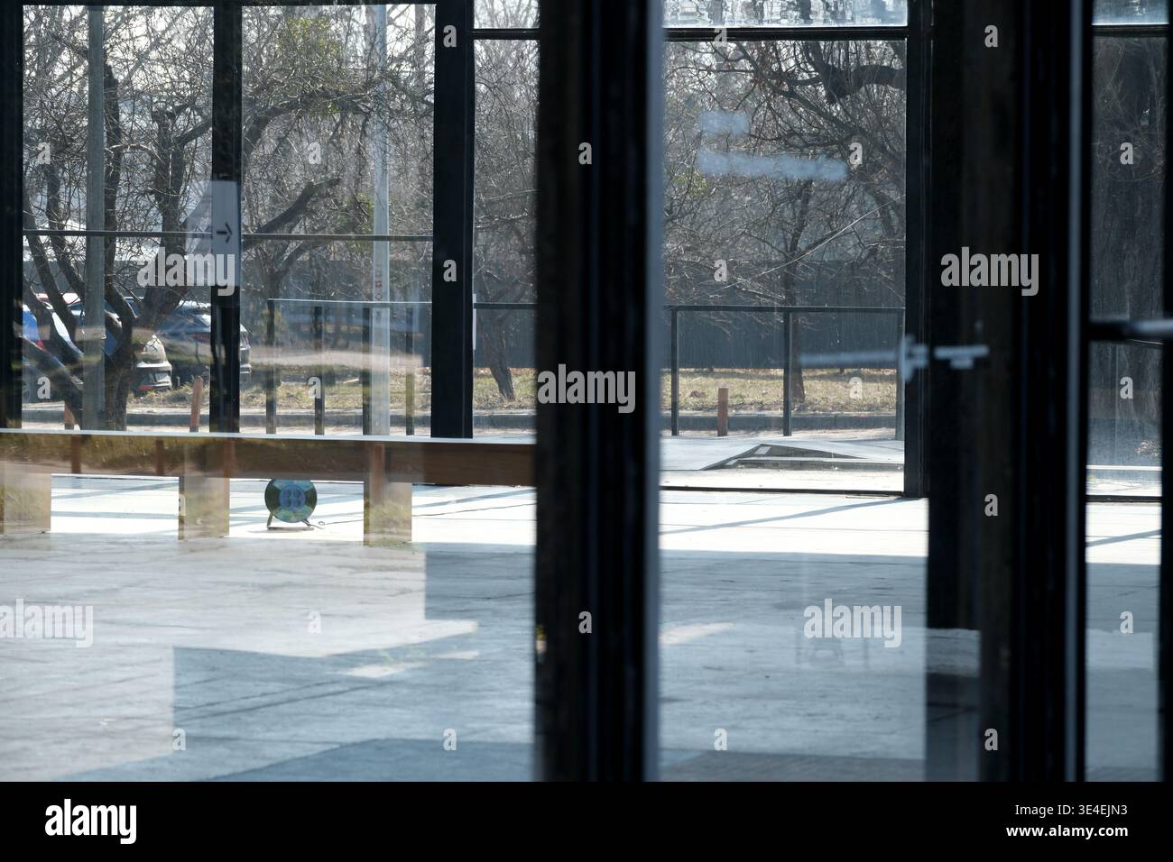 Sonnenlicht erfüllt den leeren, von Glaswänden umgebenen Raum und bietet einen ruhigen Blick. Stockfoto