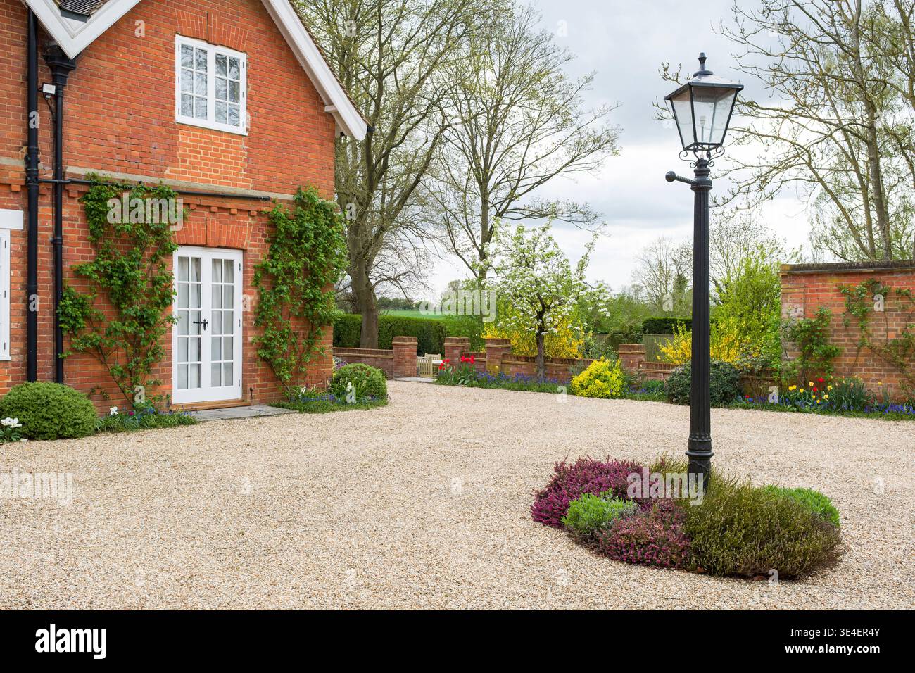 Großes englisches Landhaus, Haus mit Laternenpfahl und Hofgarten im Frühjahr, Großbritannien Stockfoto