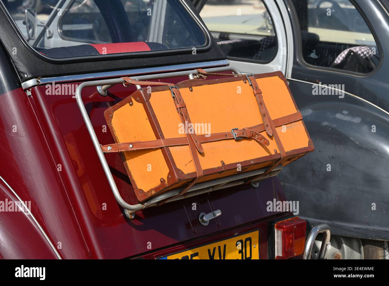 Vintage-Ledergepäck oder -Koffer an der Gepäckablage hinten oder Gepäckträger des Vintage Citroën 2CV Motorwagens befestigt Stockfoto
