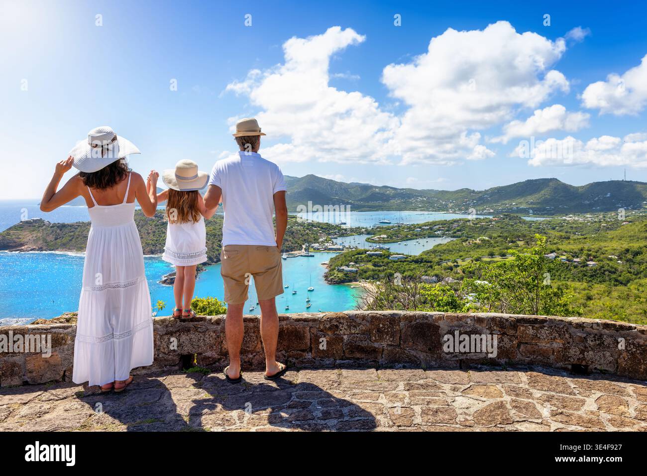 Eine Familie, die einen tropischen Urlaub macht, genießt den Panoramablick über die Landschaft der Insel Antigua mit dem Englischen Hafen und den Shirley Höhen Stockfoto