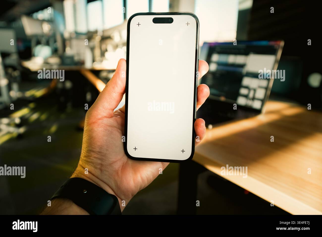 Handheld-Smartphone mit leerem Bildschirm, moderner Büroarbeitsplatz. Closeup Mensch Hand Gerät Display Vorlage Modell digitale Technologie Geschäftsumgebung Stockfoto