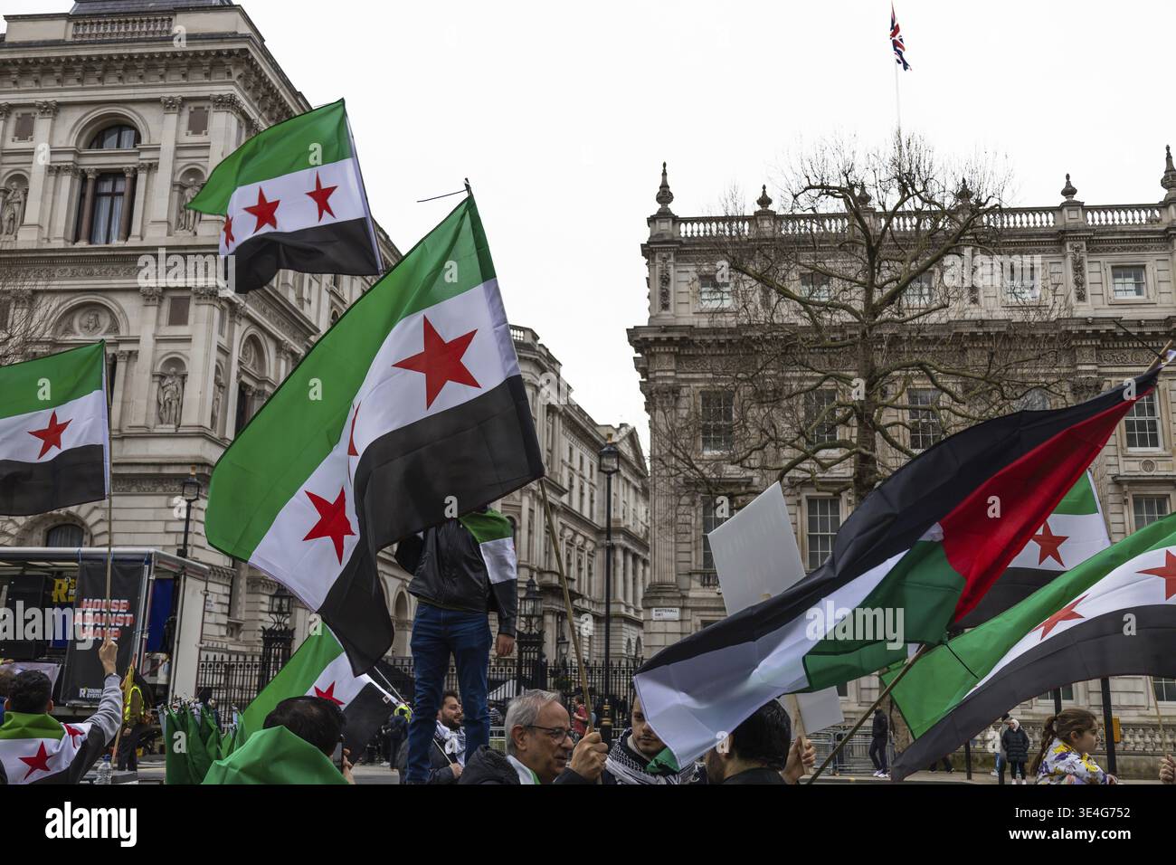 Protestbewegung mit grünen, weißen und schwarzen syrischen Fahnen mit drei roten Sternen. Demonstranten versammelten sich, um Solidarität zu bekunden und freie Forderungen zu fordern Stockfoto