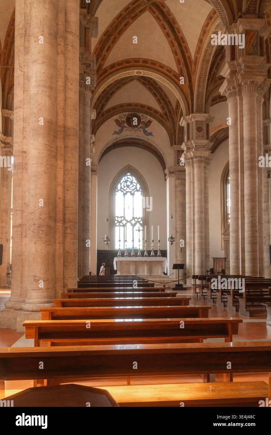 Kirchenschiff mit Bänkenreihen und gewölbter Decke. Spirituelle Atmosphäre, historisches Denkmal und religiöses Tourismuskonzept. Stockfoto
