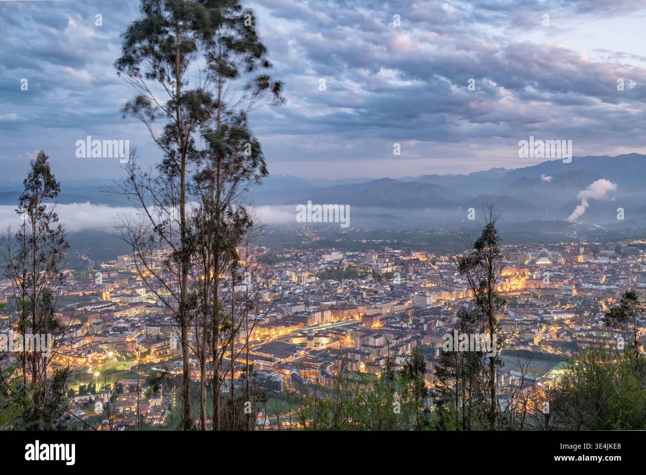 Blick von oben auf die Stadt Oviedo in der Abenddämmerung mit Bergen Stockfoto