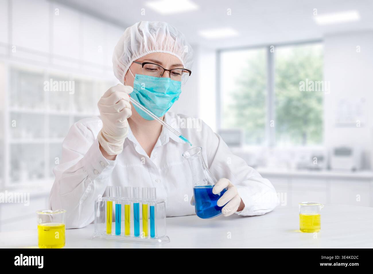 Labortechniker, der chemische Experimente mit Pipette und farbenfrohen Flüssigkeiten durchführt, wissenschaftliche Forschung und Testumgebung Stockfoto