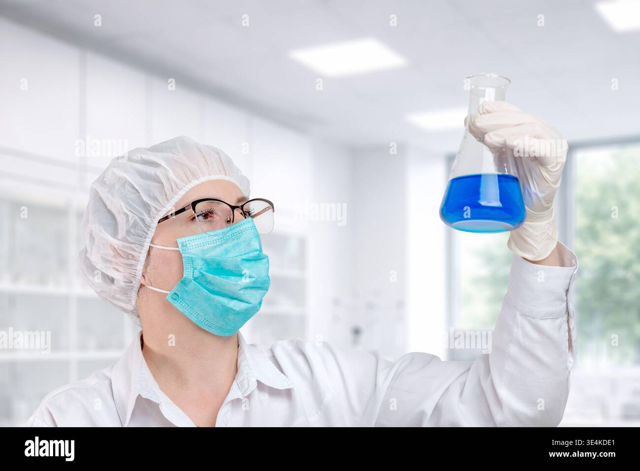Wissenschaftler zur Untersuchung der blauen Flüssigkeit im Kolben, Laborversuch und wissenschaftliche Qualitätskontrollanalyse Stockfoto