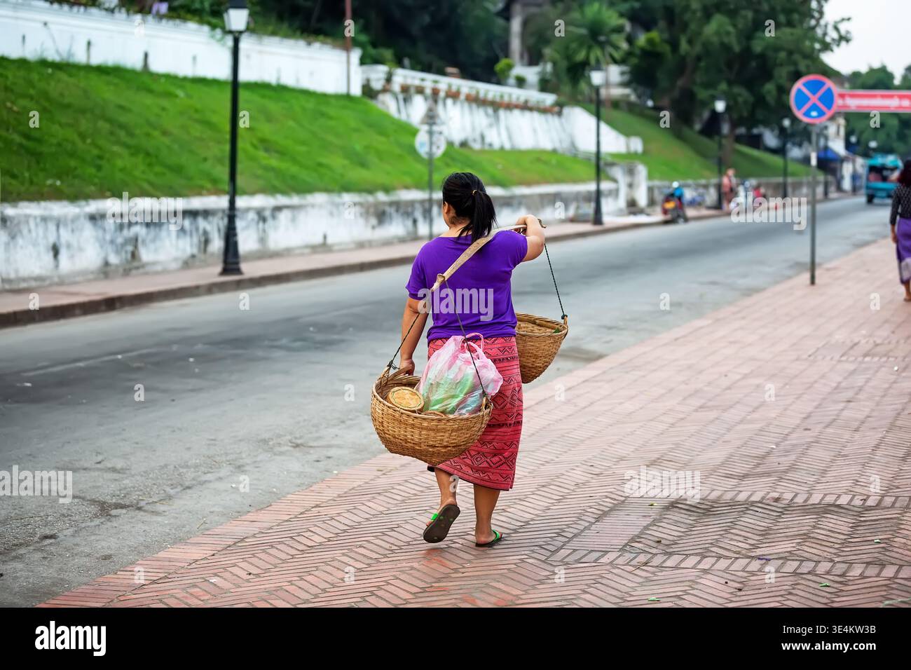 Traditioneller Straßenverkäufer mit Körben in Luang Prabang, Laos. Authentische lokale Lifestyle-Szene, die Kultur und Alltagsgeschäft in Southe widerspiegelt Stockfoto
