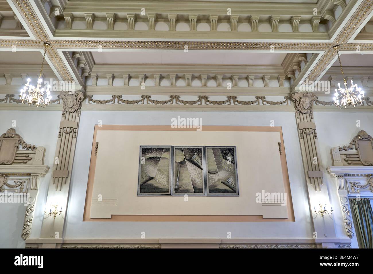 Kunstvoll verzierte klassische Inneneinrichtung mit einer kunstvoll verzierten Kassettendecke mit dekorativen Zierleisten, komplizierten Gesimsen und architektonischen Details. Zwei Stockfoto