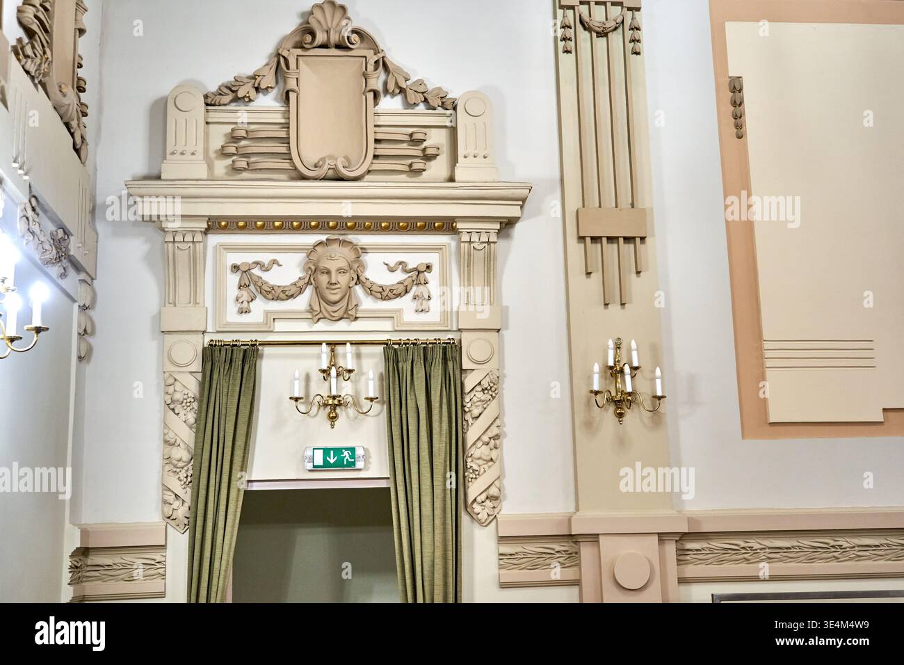 Kunstvoll verzierte klassische Innenarchitektur mit einem kunstvoll verzierten Eingang mit neoklassizistischen Zierleisten, Pilastern und einer Skulptur Stockfoto