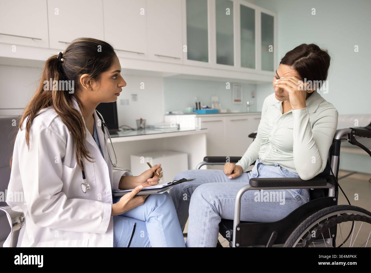 Ärztliche Beratung notleidende Patientin im Rollstuhl Stockfoto