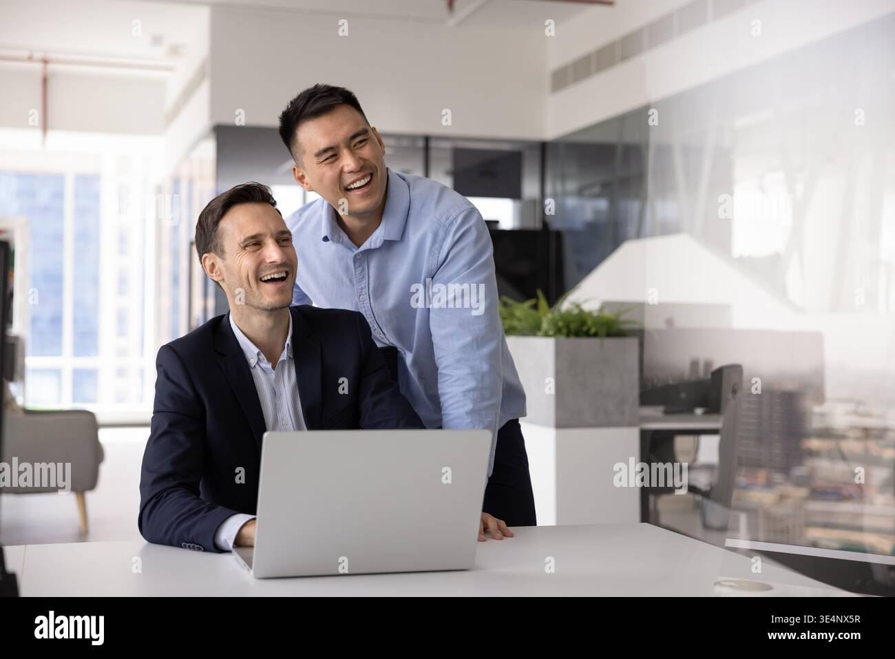 Zwei verschiedene Kollegen planen zukünftige Ziele am Schreibtisch per Laptop Stockfoto