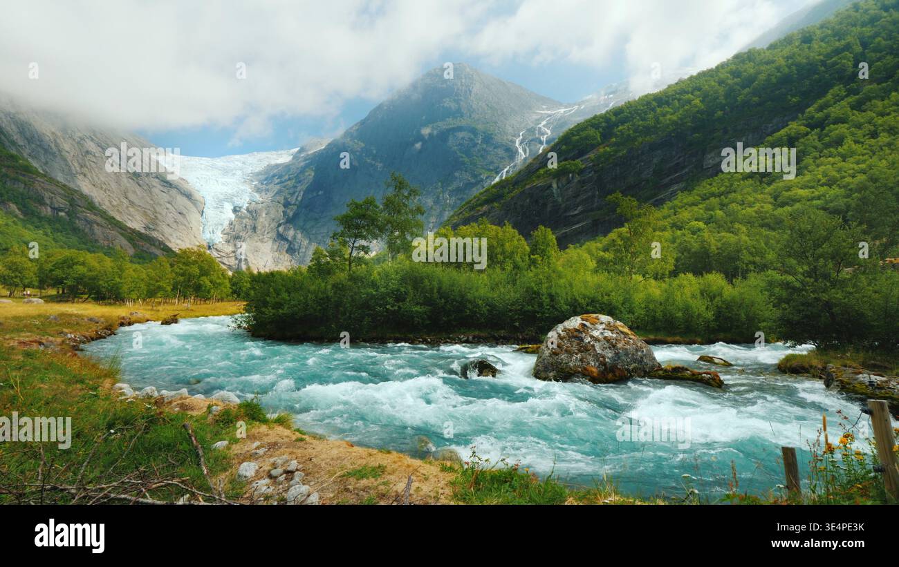 Weitlinsenaufnahme: Briksdal-Gletscher mit einem Bergfluss im Vordergrund. Die erstaunliche Natur Norwegens Stockfoto