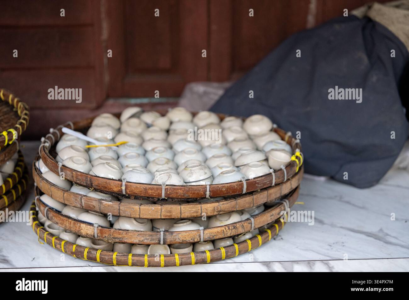 Keramikschalen sind in Bambusschalen im Teiwahakham Village Bangkok Thailand gestapelt. Stockfoto
