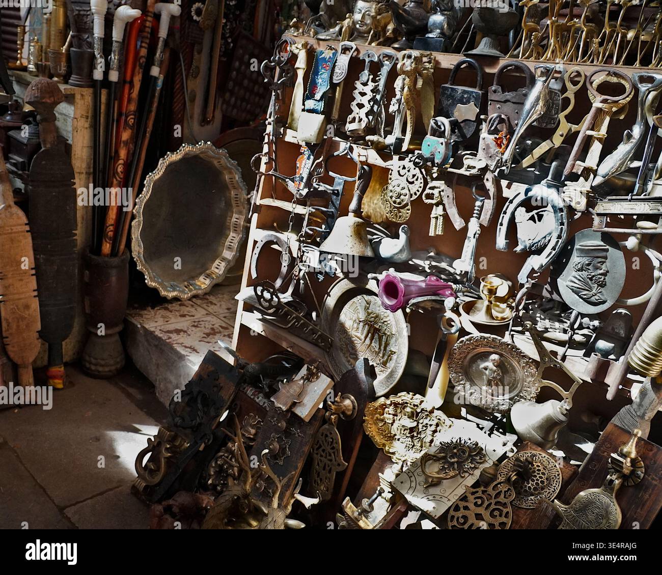 Überfüllter Stand mit Vintage-Vorhängeschlössern, Schlüsseln, Messing und Besteck auf einem traditionellen Souk-Markt in Marokko. Stockfoto